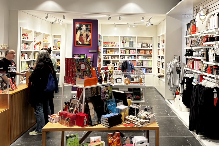 A gift shop filled with colorful items, including a poster of Shakespeare in the back.