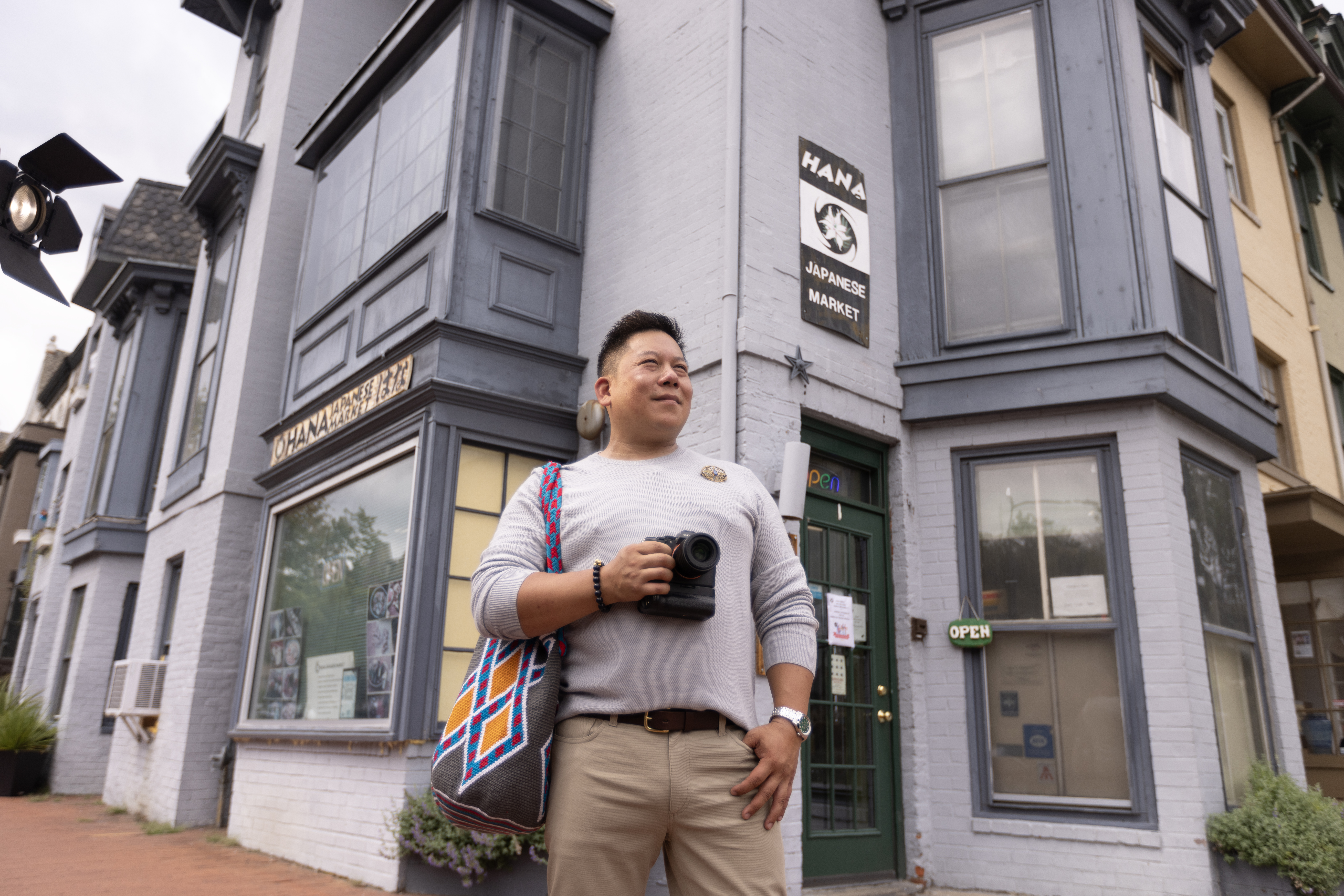 A visitor with a camera stands outside Ohana Japanese Market in Washington, DC.