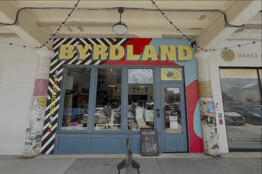 Exterior of Byrdland, a record shop with a colorful, patterned facade and string lights.