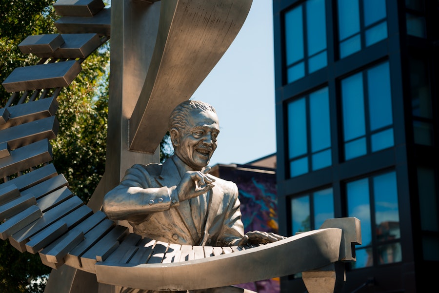 A silver-toned statue of Duke Ellington playing a grand, spiral-shaped piano stands along U Street.