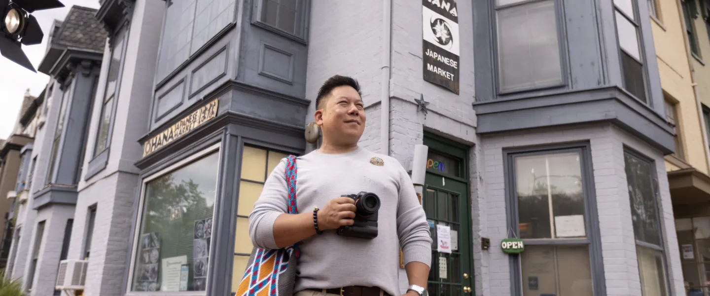 A visitor with a camera stands outside Ohana Japanese Market in Washington, DC.