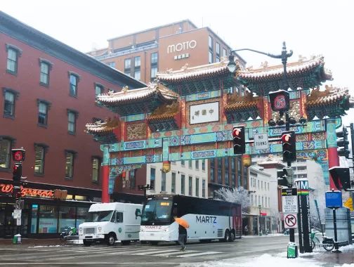 The iconic Chinatown Friendship Archway in Washington, DC, surrounded by snow-covered streets.